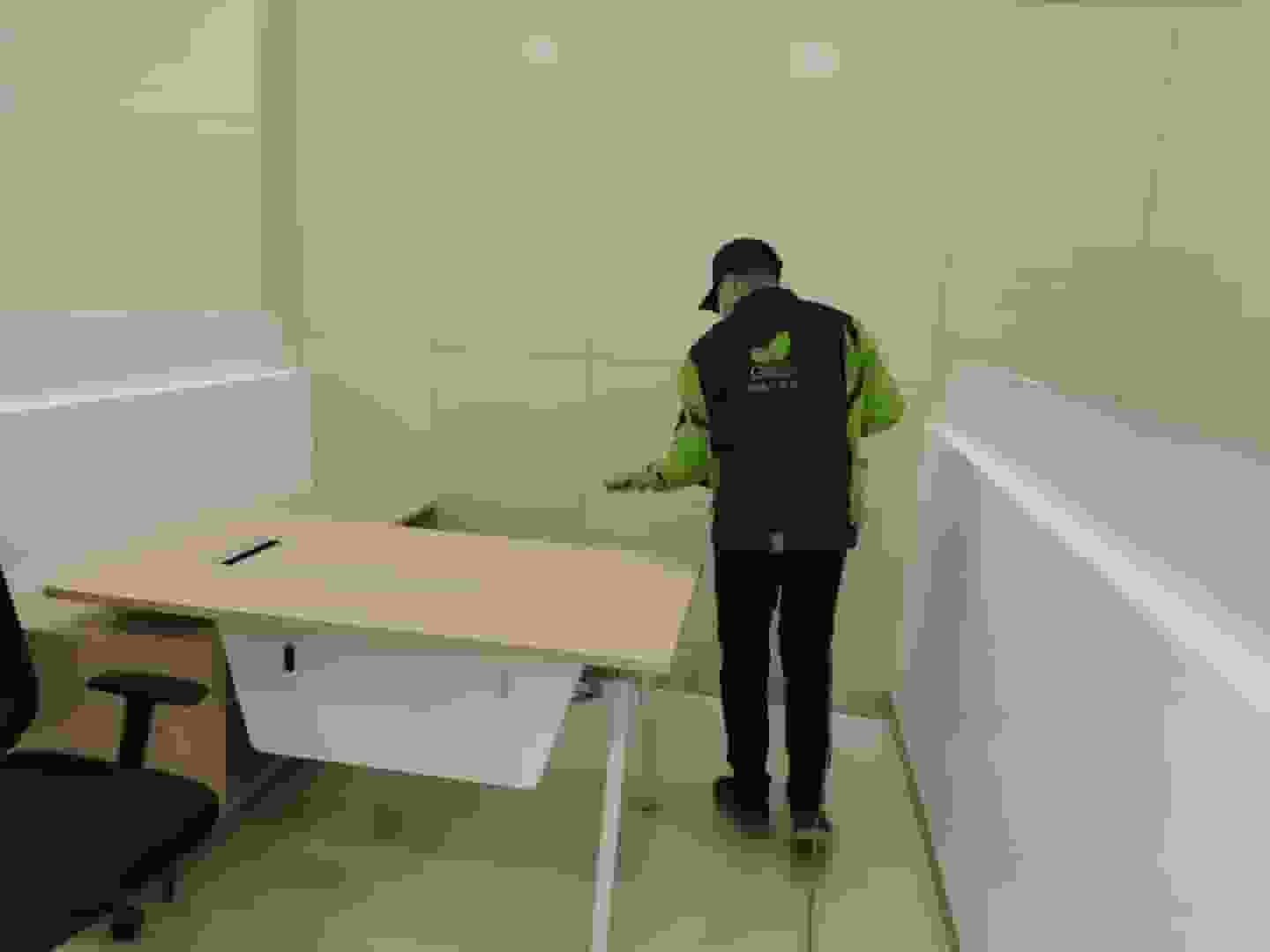 书房内,施工人员将书架上的书籍整理收纳,为书架的除醛作业腾出空间。