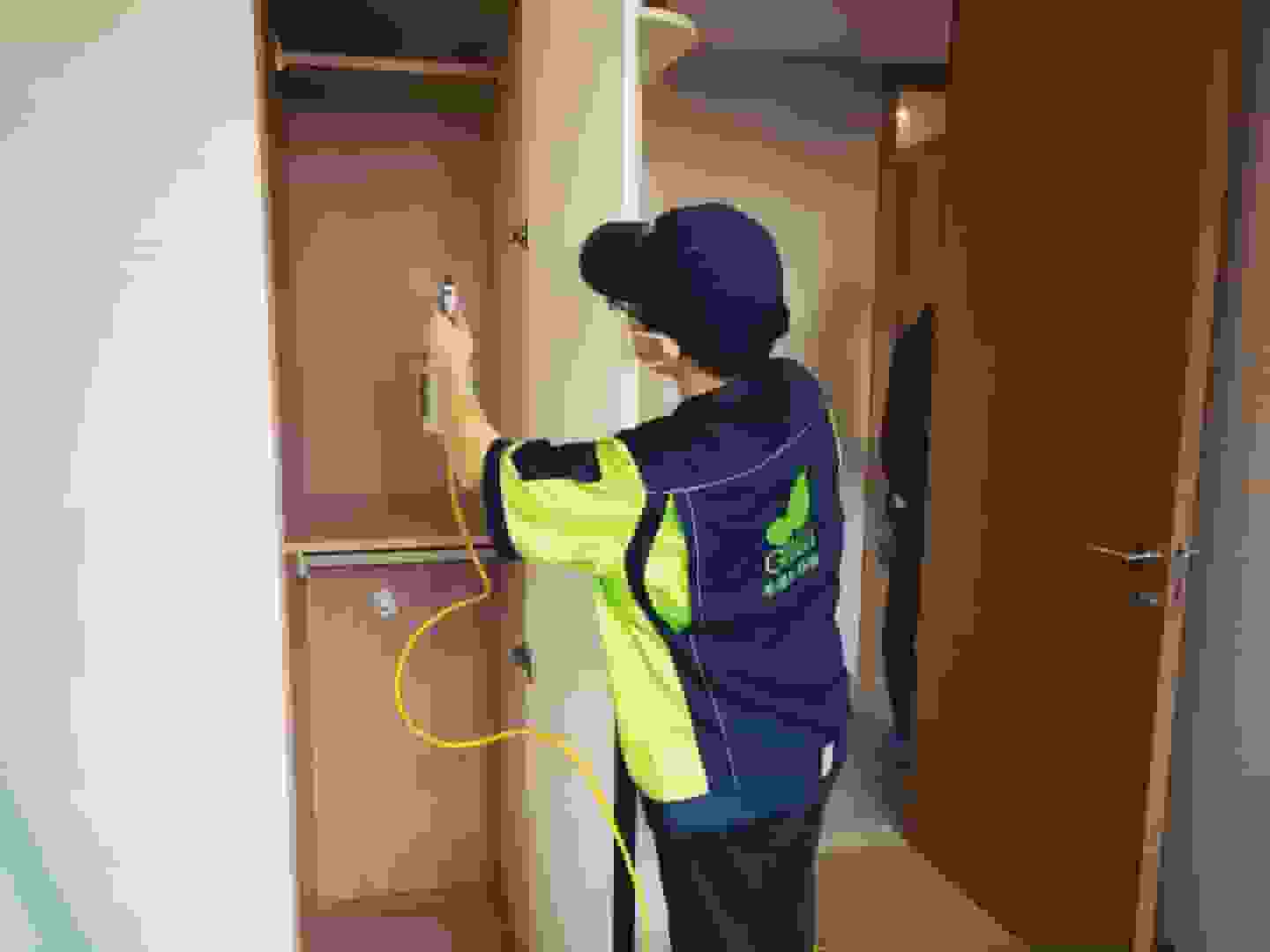 卧室中,工作人员将床上用品收纳起来,并用防尘罩将床体覆盖,做好施工防护。